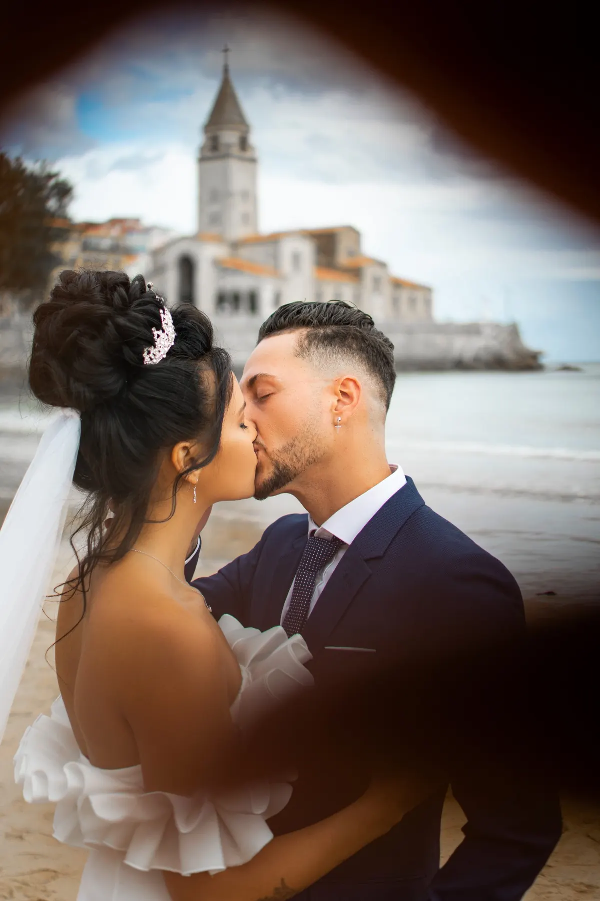 Pareja de novios besándose con una iglesia al fondo
