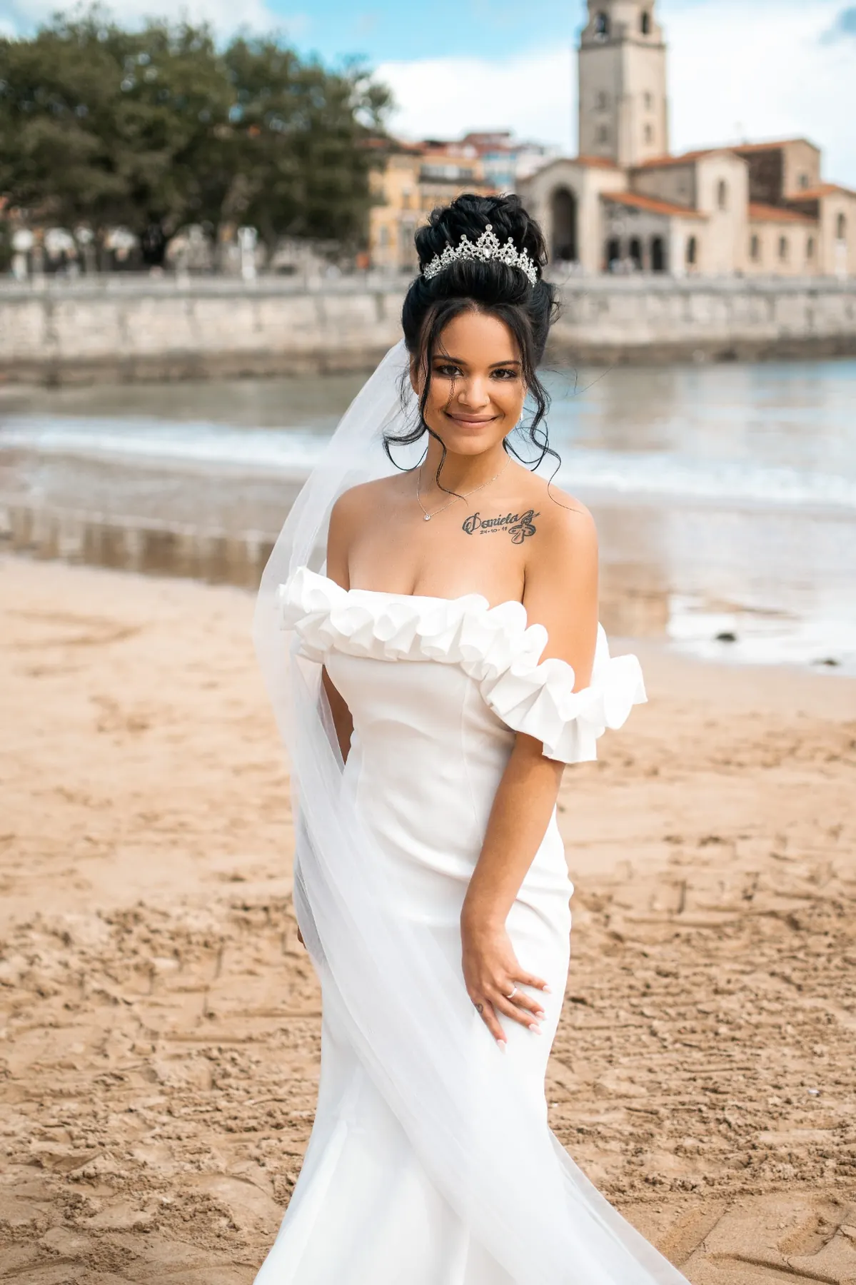 Retrato de la novia en la playa con la iglesia al fondo