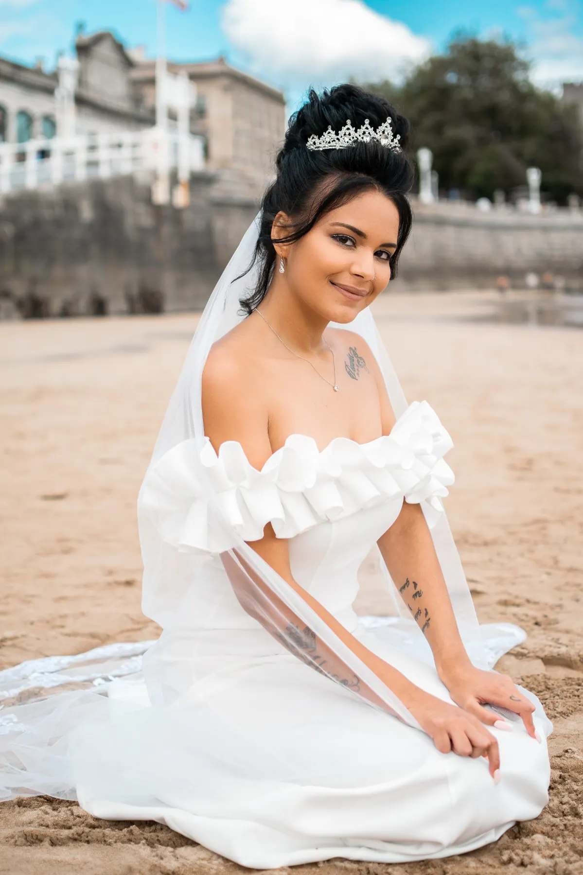 Retrato de novia sentada en la arena