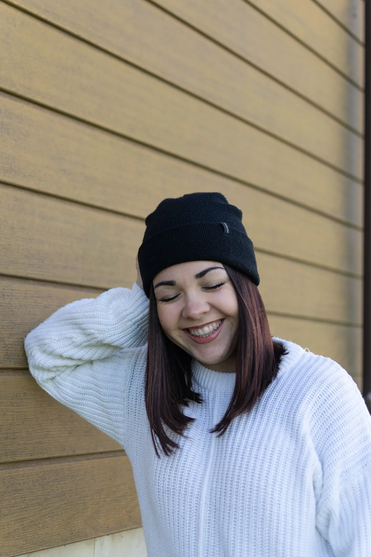 Retrato espontáneo sonriendo junto a una pared